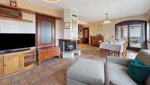 Ein Wohnzimmer mit Kamin, Fernseher und Sitzgelegenheit.