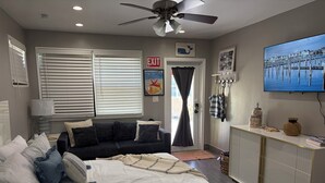 Una habitación de hotel con cama, sofá, televisor y escritorio.