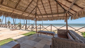 A covered outdoor seating area with a view of the beach. - Eco Paradise #101 - Apt in Cumbuco by Carpediem (Caucaia)
