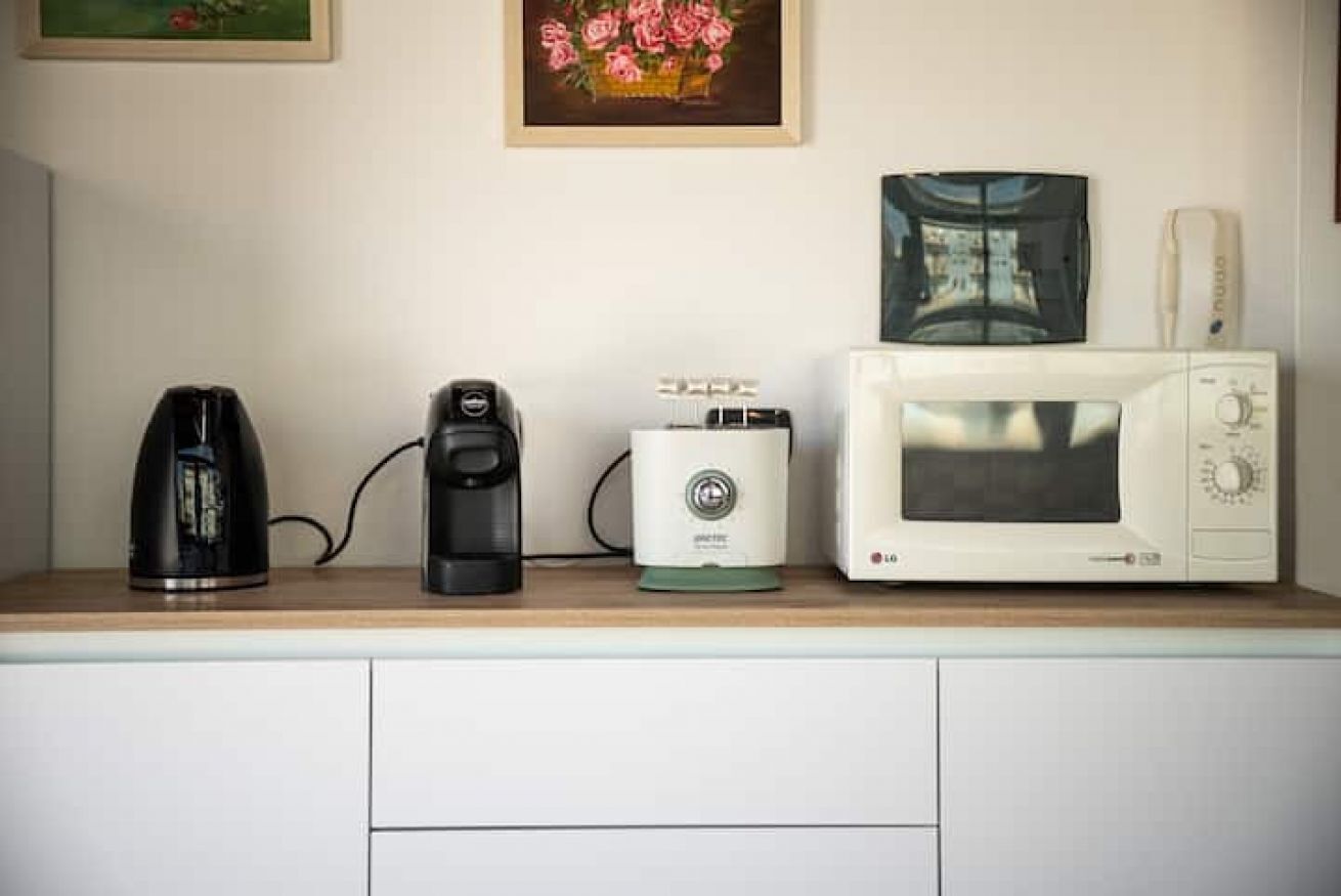 Un plan de travail de cuisine avec une machine à café, un grille-pain et un four à micro-ondes.