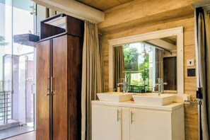 A bathroom with a wooden ceiling, a large mirror above a double sink, and a cabinet with a towel rack. - Modern Open-Plan Loft for 5 in the Heart of Point Pedro (Point Pedro)