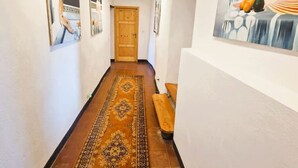 A hallway with a patterned rug, wooden bench, and artwork on the walls. - Authentic Tuscany Stay with Epic Views & Space for All (Cardoso)