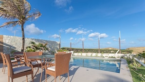 An outdoor pool area with wicker furniture and a stone wall. - Luxo a Beira Mar - Mansao Exclusiva por Carpediem (Extremoz)