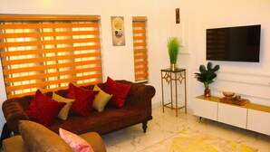 Una sala de estar con un sofá, una mesa de centro y un televisor montado en la pared.