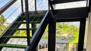 Eine moderne Außentreppe führt zu einem Poolbereich mit Blick auf eine Wohngegend.