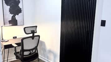A modern office space with a desk, office chair, and a sliding door.