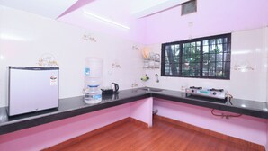 A kitchen with a refrigerator, water dispenser, sink, and gas stove. - Sanjana The Luxurious Family Stay 1 (Karkala)