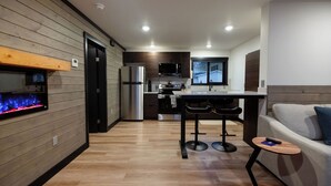 A modern kitchen with wooden paneling, stainless steel appliances, and a bar area. - ATI Unit B: 1  BR, 1  BA Duplex in Sitka, Sleeps 3 (Sitka)
