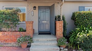 Una casa residenziale con una porta d'ingresso grigia, numero 2151, e un ingresso in mattoni.