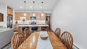 A modern kitchen with wooden cabinets, a central island, and pendant lighting. - Buffalo Mtn Views - Spacious Dillon Retreat (Dillon)