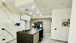 A modern kitchen with a marble backsplash, a central island, and recessed lighting. - Milano Bicocca Apartment & Rooms (Cinisello Balsamo)