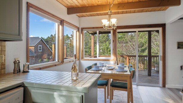 Una cocina con una isla grande, techo de madera y ventanas amplias que ofrecen vistas al exterior.