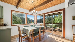 Un comedor con una mesa, sillas y vistas amplias a una terraza exterior.