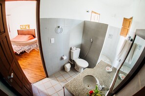 A bathroom with a toilet, sink, and shower.