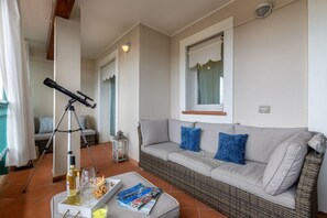 Ein gemütliches Wohnzimmer mit einer Couch, einem Teleskop und einer Serviertablett mit Snacks und Getränken.