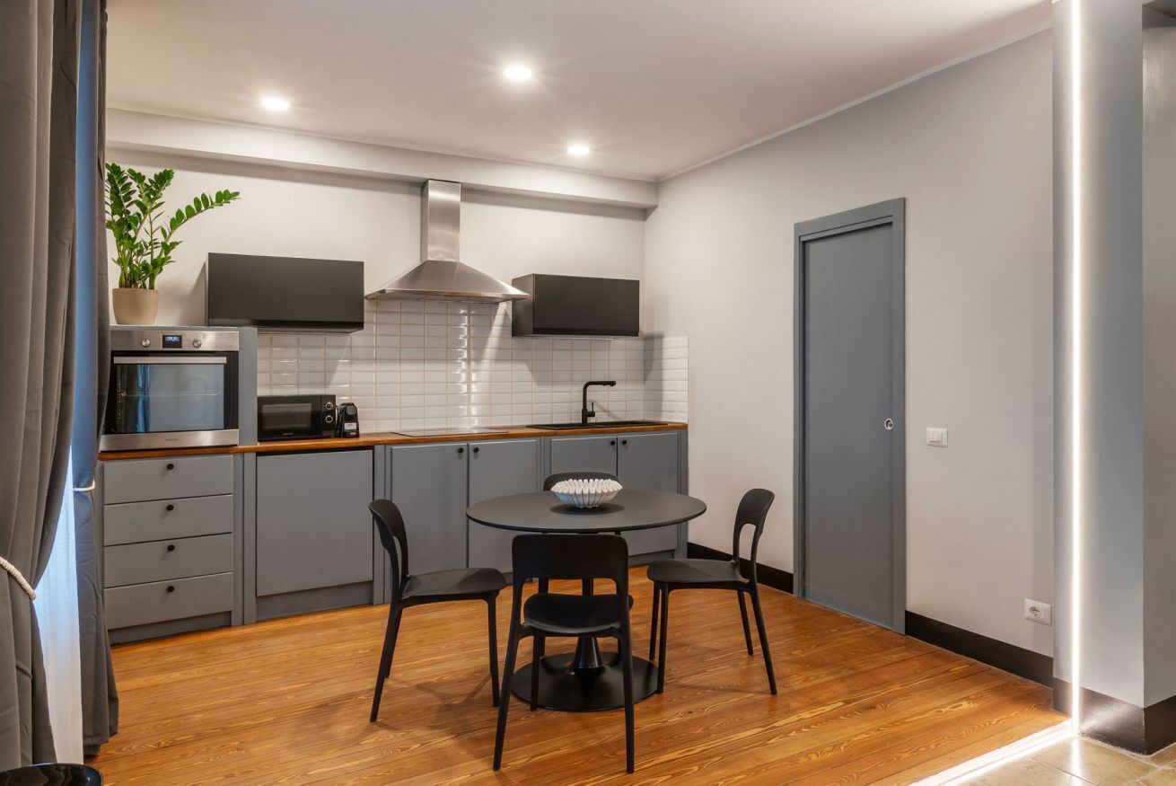 A compact kitchen with a microwave, stove, and modern cabinetry.