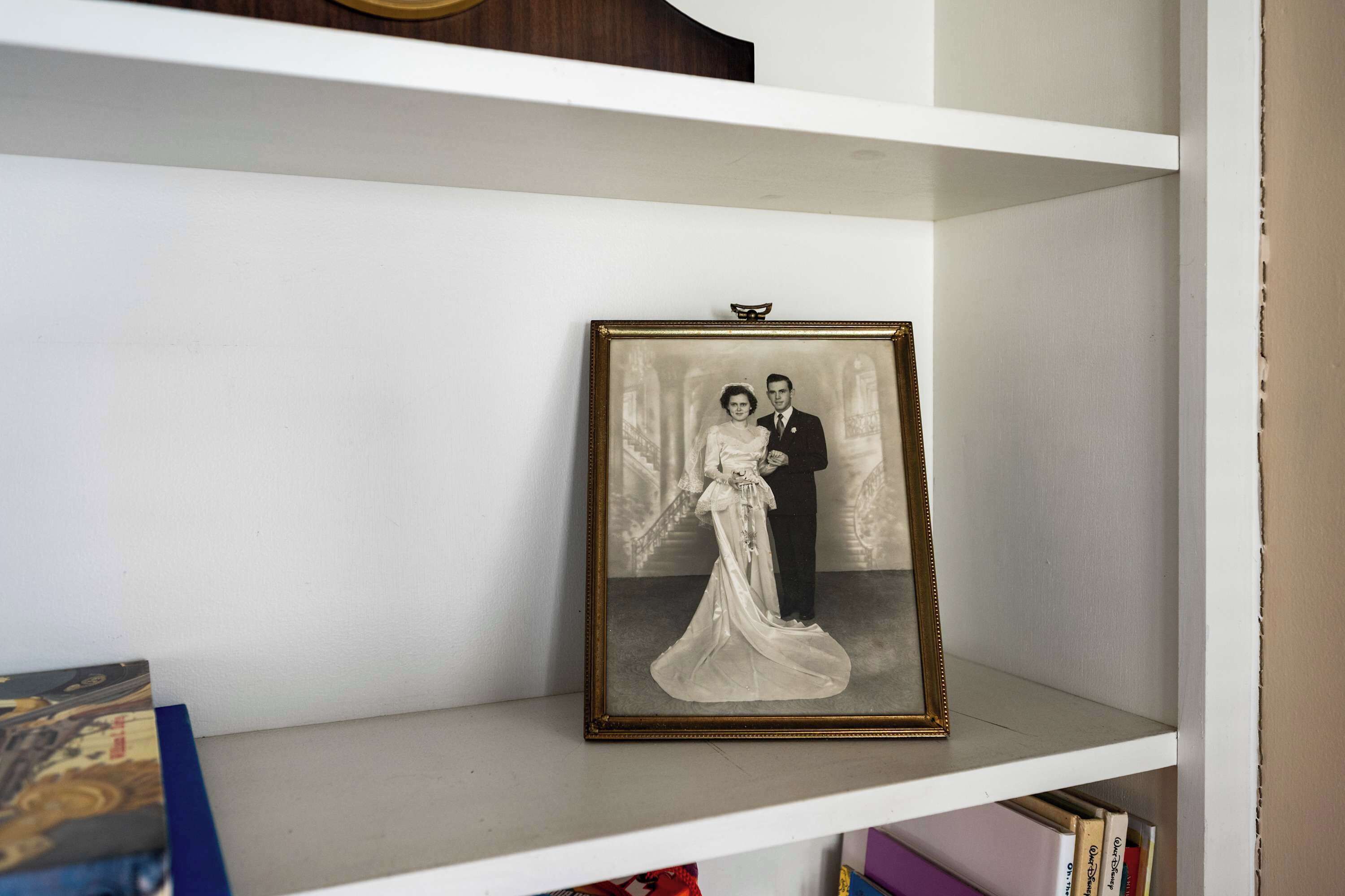 A framed photograph on a white shelf.