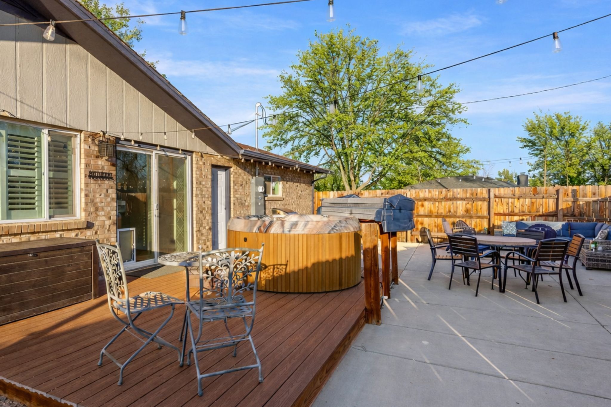 A wooden deck with outdoor furniture, a hot tub, and a barbecue area.