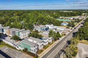A residential area with multiple-story houses, a main road, and surrounding greenery. - Boutique Downtown Cottage with Golf Cart (Ocean Springs)