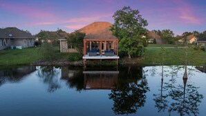 A gazebo by a calm pond with a stone house in the background. - Spacious 4-bedroom house with AC in fabulous Gulfport (Gulfport)