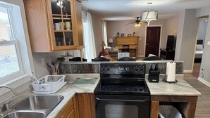 Una cucina con forno, lavello e pensili in legno.