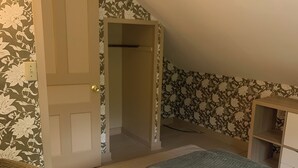 A bedroom with a bed, a wardrobe, and a door leading to another room. - Cozy 1-bedroom apartment in old farm house in historic South Lee (Lee)
