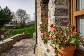 Un bâtiment en pierre avec une fenêtre et un pot de fleurs.