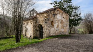 Un vieux bâtiment en pierre doté d’un clocher, de portes en arc de cercle et d’une entrée pavée.