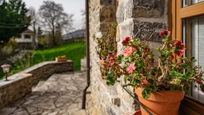Un bâtiment en pierre avec une fenêtre et un pot de fleurs.