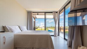 Ein Schlafzimmer mit einem Bett, einem Schreibtisch und einem großen Fenster mit Vorhängen.