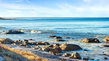 A coastal landscape with rocky shores and clear blue water.