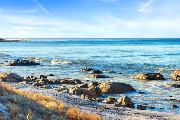 A coastal landscape with rocky shores and clear blue water.