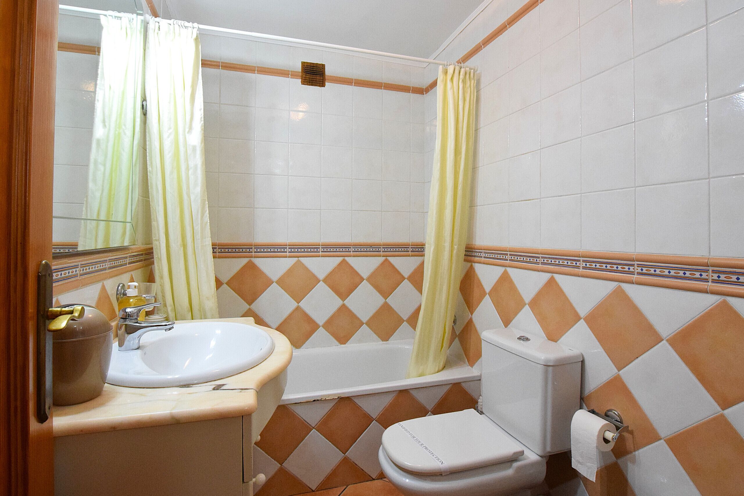 A bathroom with a sink, toilet, and bathtub.