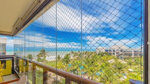 A balcony with a view of a beach and palm trees. - Wai Wai #a406 - Beachfront Resort By Carpediem (Caucaia)