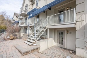 Un edificio residencial de varios pisos con una escalera que lleva a la entrada.