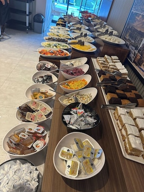 Ein reichhaltiges Buffet mit verschiedenen Speisen und Beilagen auf einer langen Tafel.
