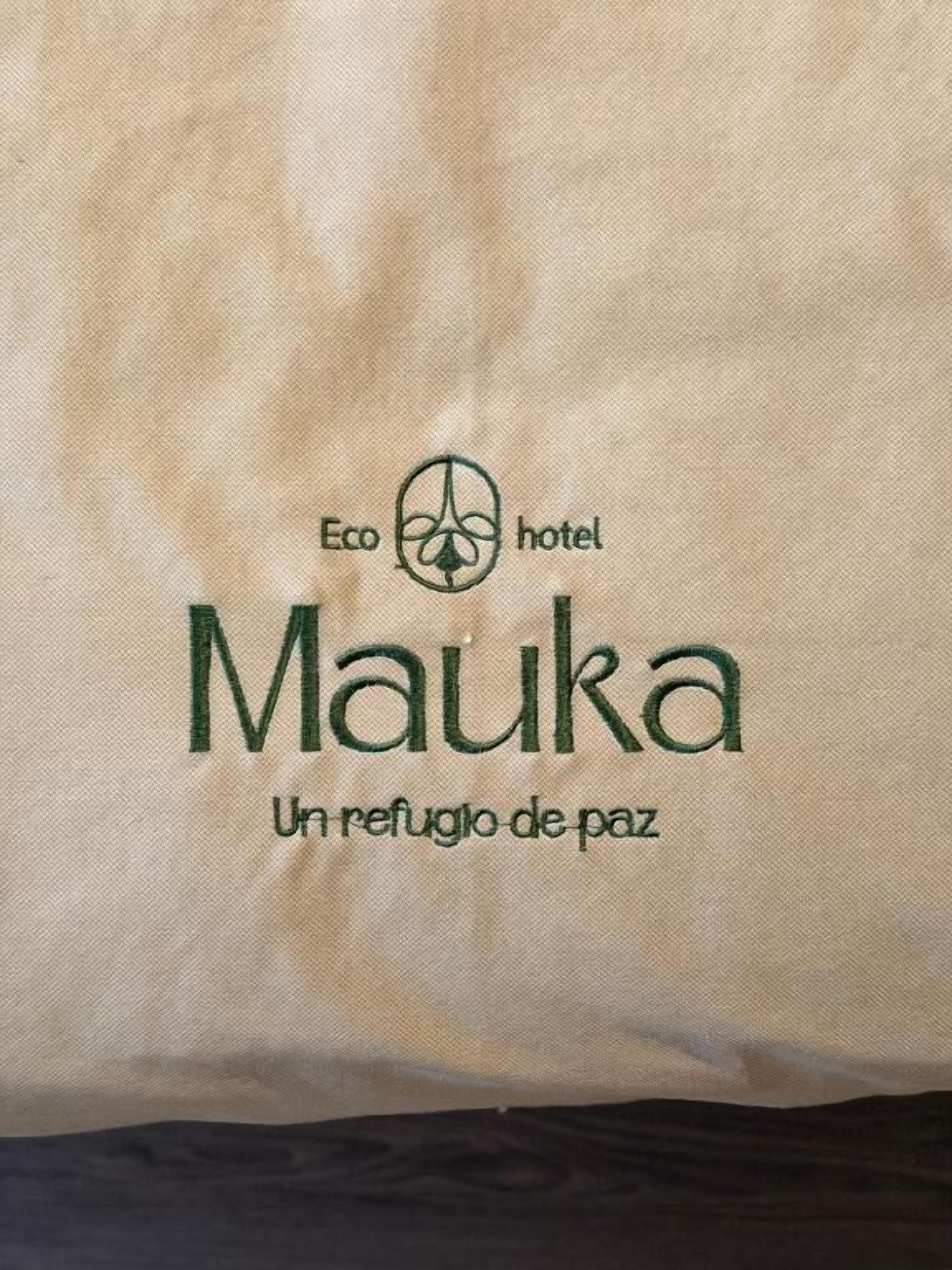 A hotel bag with the logo 'Eco hotel Mauk a Un refugio de paz'.