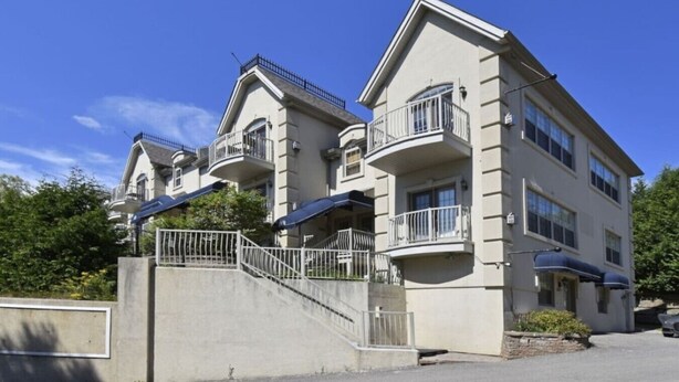 A multi-story residential building with balconies, a concrete staircase, and a clear sky. - Condo Alpina – 3105 | Cozy Retreat in St-Sauveur (Piedmont)