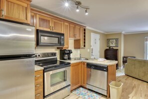 A modern kitchen with stainless steel appliances, wooden cabinets, and a dishwasher.