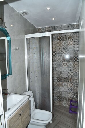 Ein Badezimmer mit Dusche, Toilette und Waschbecken.