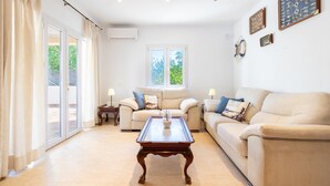 Ein Wohnzimmer mit einer Couch, einem Couchtisch und einem Fenster mit Vorhängen.