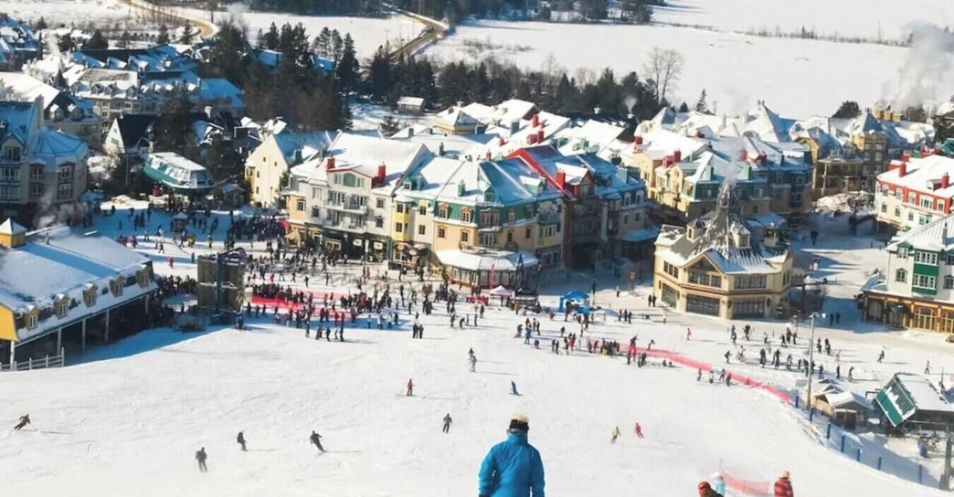 A snowy town with a ski slope and buildings.