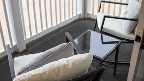 A balcony with a glass table and two chairs with cushions. - Waterway Getaway - Myrtle Beach (Myrtle Beach)