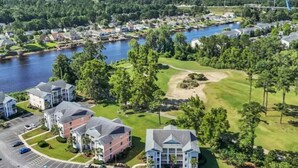 A residential area with multiple two-story houses, a golf course, and a lake. - Waterway Getaway - Myrtle Beach (Myrtle Beach)