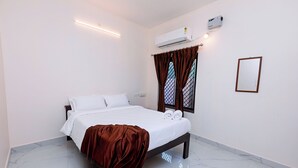 A hotel room with a bed, white walls, a window with curtains, an air conditioning unit, and a mirror. - Welcome Grand Private Pool Villa (Vanur)