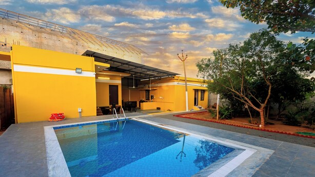 A swimming pool with a clear blue water surface, surrounded by a tiled deck. - Welcome Grand Private Pool Villa (Vanur)