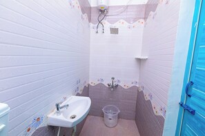 Un baño con lavamanos, ducha e inodoro.