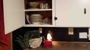 Una cocina con armarios abiertos que exhiben vajilla y cristalería.