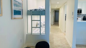 Un dormitorio con literas, un cuadro en la pared y una ventana con vistas.