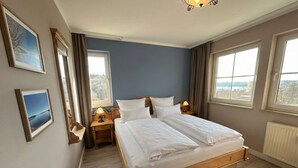A bedroom with a double bed, two bedside tables, a nightstand, a window, and a view of the outdoors. - Suite Seensucht am malerischen Brombachsee (Spalt)